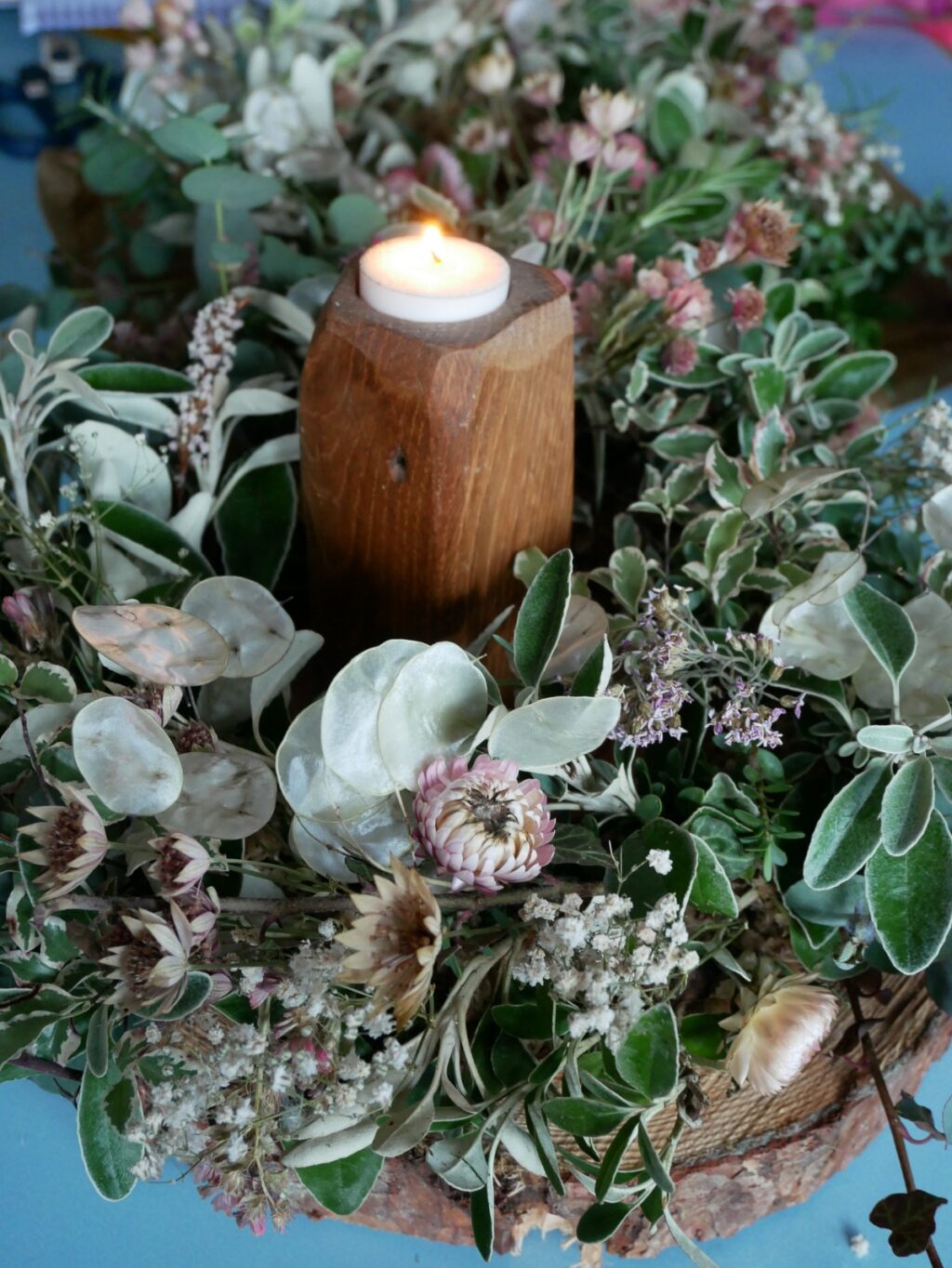 A wedding flower centrepiece for winter with foliage and dried flowers. Clodhopper Blooms.
