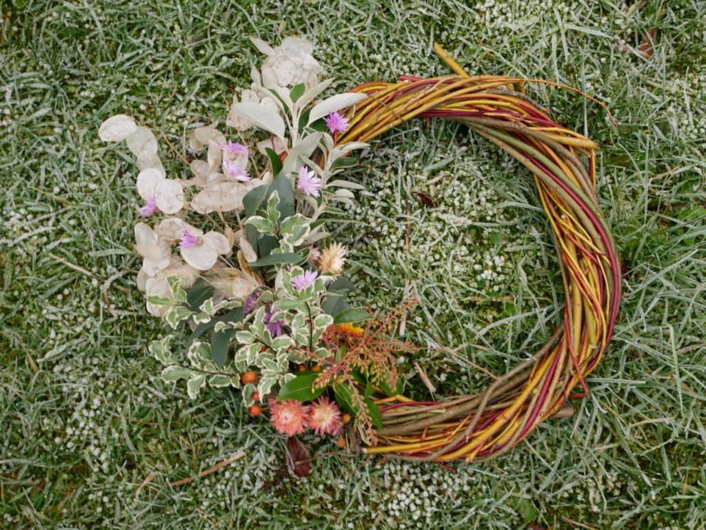 Multi-coloured willow whips make an eye-catching base for this winter wreath