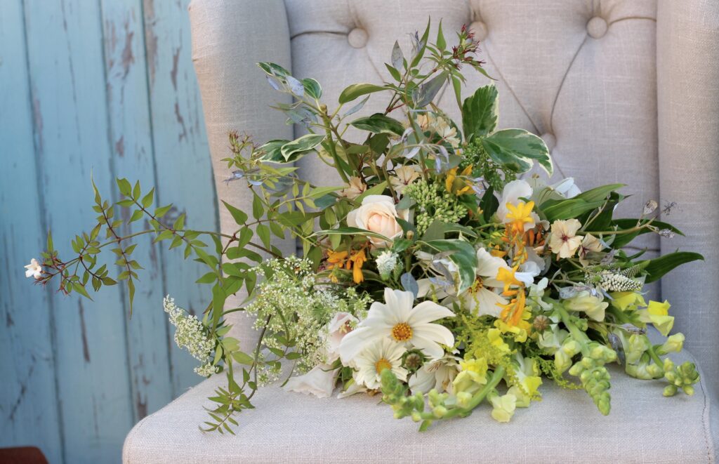 A leafy summer wedding bouquet with jasmine trails, variegated ivy leaves and summer flowers in yellows and whites. Photo: Tuckshop Flowers