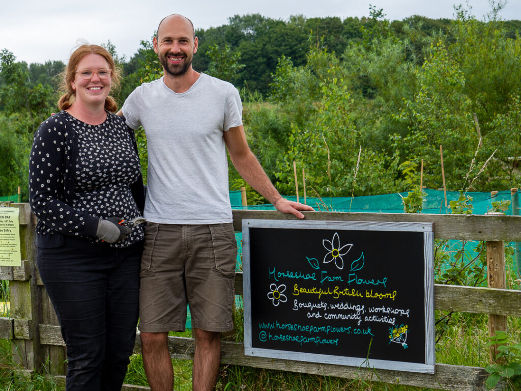 Laura and Martin of Horseshoe Flower Farm are new members of Flowers from the Farm and love working on their Lancashire flower farming business. Here they're standing proudly by the gate to the flower farm with a sign which tells the public exactly what they do
