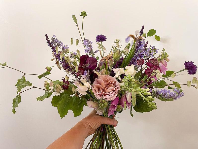 A bridal bouquet for a June wedding features garden-gathered roses, astrantia, Sweetpeas, grasses and lots of other examples of seasonal bounty! by The Cutting Garden, Gloucestershire.