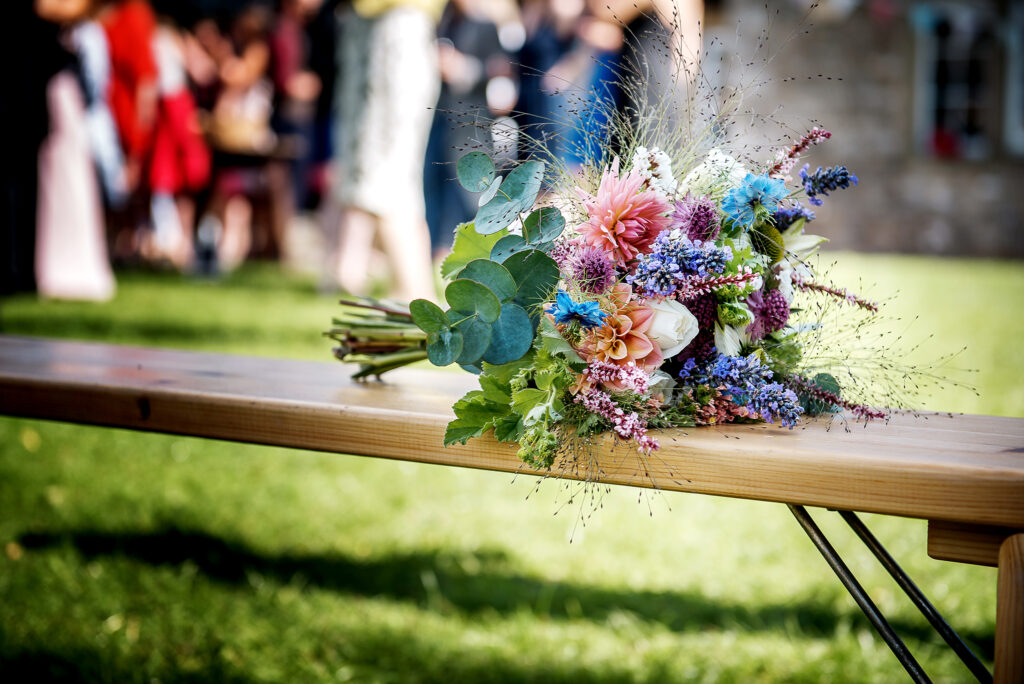A seasonal summer wedding bouquet of British flowers by Pear Tree House Flowers. Peach dahlias with love in a mist for something blue, lavender for gorgeous perfume, grasses and eucalyptus for texture. Photo: RD Photography.