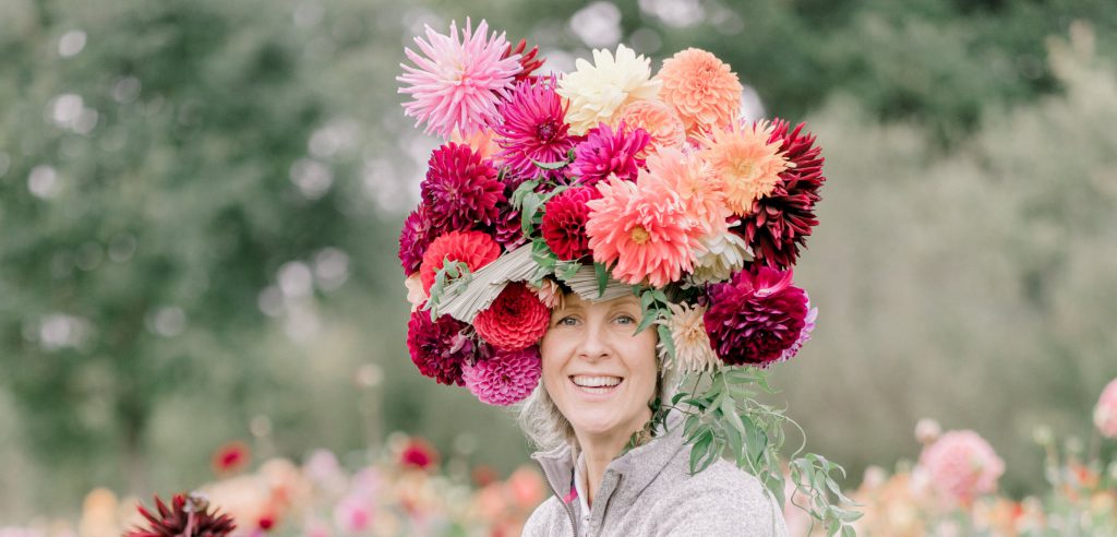 Justdahlias Philippa wears the flowers that she's obsessed with piled high in a towering hat made of richly coloured blooms.