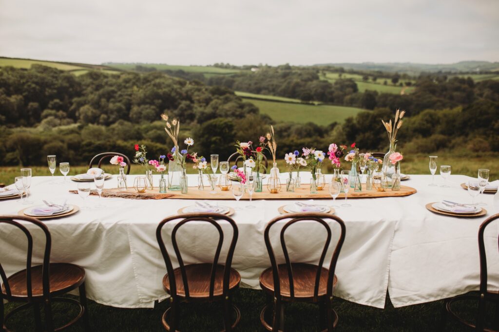 A botanical wedding table by Sweet Peas and Sunflowers photographed against the Devon countryside by Holly Collings Photography.