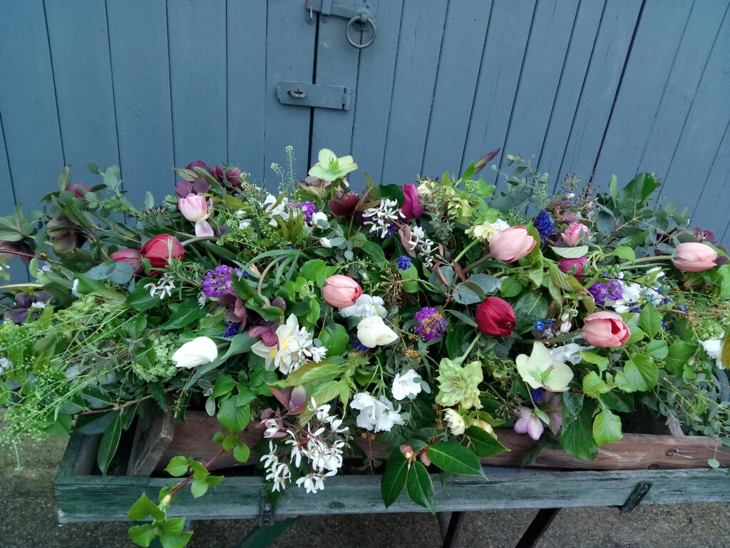 A colourful spring casket spray by the Yorkshire Dales Flower Company.